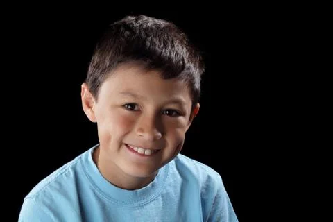 Smiling boy on black background with dramatic side lighting Stock Photos