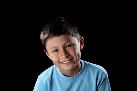 Smiling boy on black background with dramatic side lighting Stock Photos