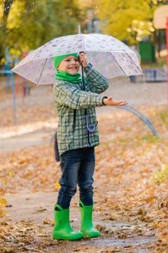 Smiling boy catch rain drops from umbrella Stock Photos