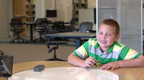 Smiling boy continues to do math problems Stock Footage 26585959