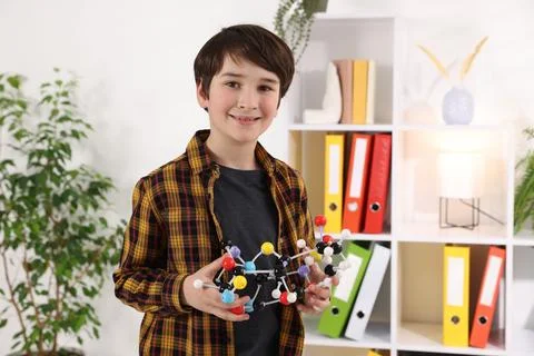 Smiling boy with DNA structure model indoors Stock Photos