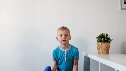 Smiling boy is doing exercises with dumbbells in his room Stock Footage 88396076