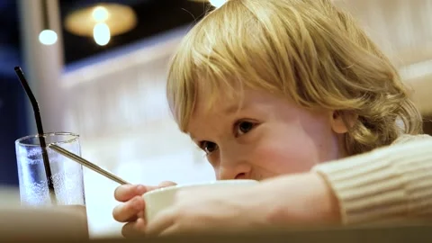 Smiling boy eating soup in cafe Stock Footage 305141433
