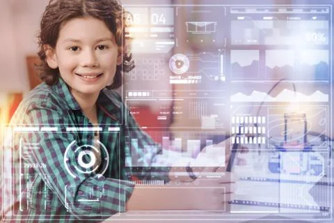 Smiling boy feeling glad while sitting at the interesting lesson Foto stock