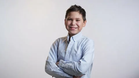 Smiling boy folding hands on white background. Video stock 239624620