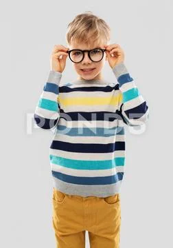 Smiling boy in glasses and striped pullover Stock Photos