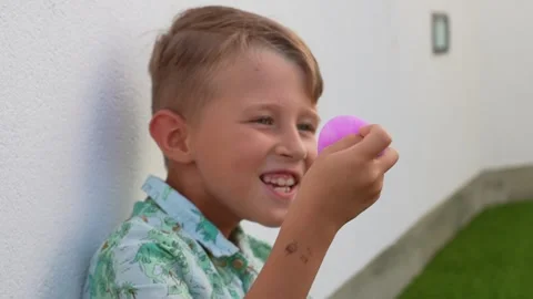Smiling Boy Holding a Purple Squishy Toy at Home Vídeos de archivo 341830558