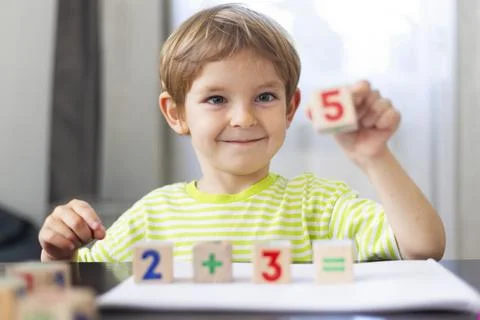 Smiling boy learning math with wooden blocks 스톡 사진