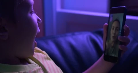 Smiling  boy  looks to the screen smartphone and speaking with his mother.    Stock Footage 118520899