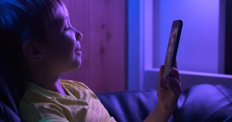 Smiling  boy  looks to the screen smartphone and speaking with his mother. Stock Footage 119004112