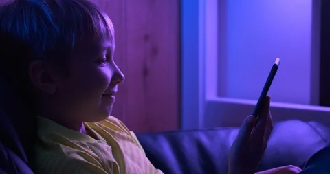 Smiling  boy  looks to the screen smartphone and waves to his mother. Caucasi Stock Footage 119527345