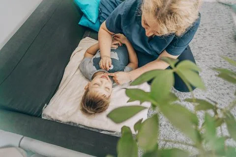 Smiling boy lying on blanket during a therapy session with a female specialist Stock Photos