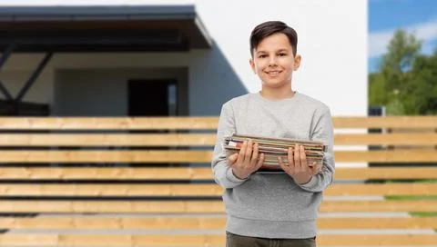 Smiling boy with magazines sorting paper waste Stock Photos