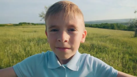 Smiling Boy Making Heart Shape with Hands Outdoors in Summer Field Stock Footage 311574899