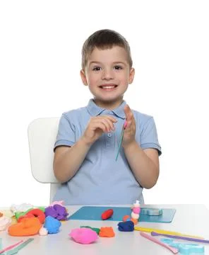 Smiling boy with play dough handiwork at table on white background Stock Photos