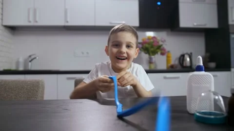 Smiling boy playing with long handmade slime Stock Footage 104007376