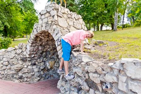 Smiling boy playing on stone wall Stock Photos