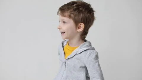 Smiling boy posing isolated on white wall background. Looking at camera showi Stock Footage 168907277