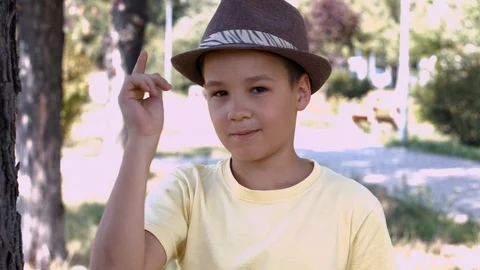 Smiling Boy Puts A Hat On Head and winks Close Up Stock Footage 116089676