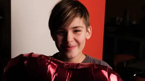 Smiling boy with red heart shaped balloon Stock Footage 146025673