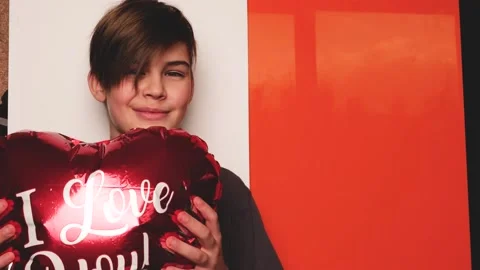 Smiling boy with red heart shaped balloon Stock Footage 146025971