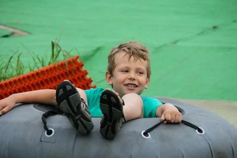 Smiling boy slides down in inflatable ring Stock Photos