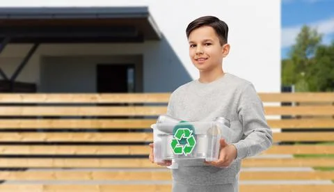 Smiling boy sorting metallic waste over house Stock Photos