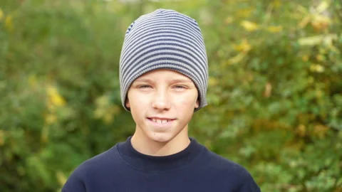Smiling boy in striped hat standing in park look at camera. Handsome kid stylish Stock Footage 167771411