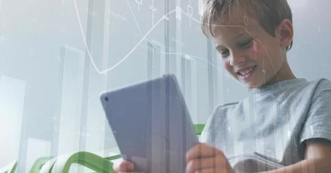 Smiling boy studying charts on tablet in bright room with green chair, graph Stock Photos
