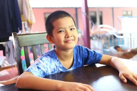 Smiling Boy at Table in Bright Indoor Setting Stock Photos
