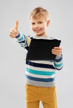 Smiling boy with tablet computer showing thumbs up Stock Photos