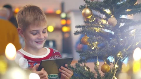 Smiling boy with tablet pc computer near christmas tree at home Stock Footage 144108594