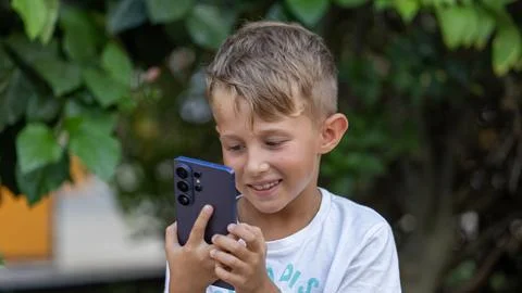 Smiling Boy Using Smartphone Outdoors in Summer Park Portrait Stock Photos