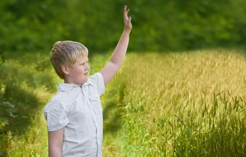 Smiling boy waves his hand on a walk in the Park Stock Photos