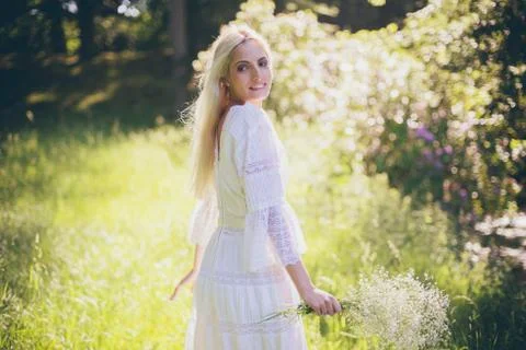 Smiling bride in forest looking over shoulder Stock Photos