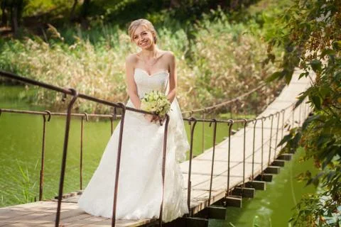 Smiling bride on river bridge Stock Photos