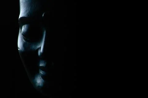 Smiling Buddha face on black background. Stock Photos