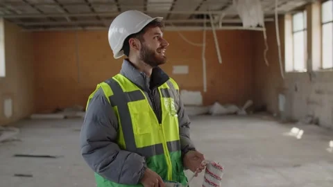 A smiling builder looks around the construction site. Excited building Stock Footage 237032418