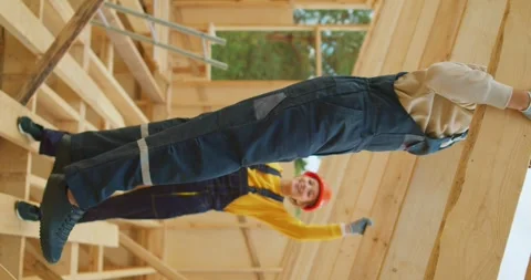 Smiling builder worker powerlifter pulling up in unfinished wooden construction Stock Footage 255846029