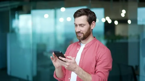 Smiling business man freelancer hold smartphone scrolling and watching social  Stock Footage 234152011