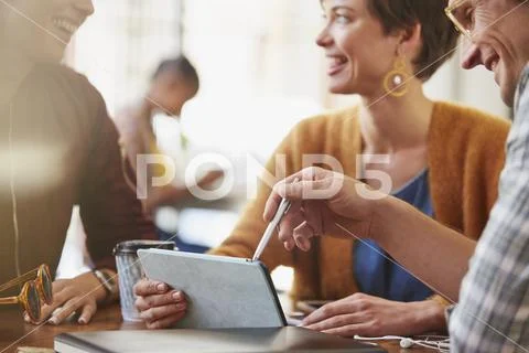 Smiling business people meeting using digital tablet in cafe Stock Photos