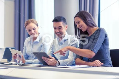 Smiling business people with tablet pc in office Stock Photos
