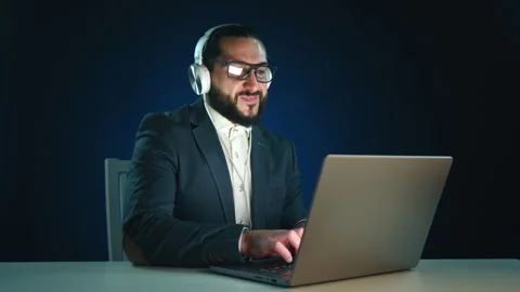 Smiling Businessman with Headphones Using Computer Stock Footage 265432722