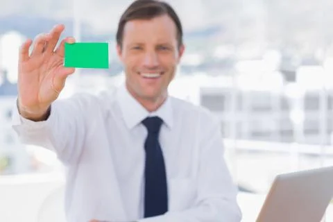 Smiling businessman holding a green business card Stock Photos