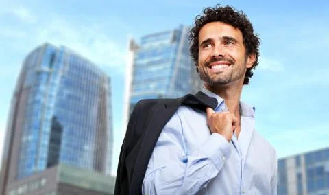 Smiling businessman holding his jacket outdoor Fotos de archivo