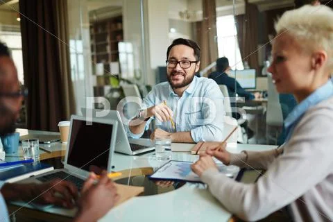 Smiling businessman listening to his colleague idea Stock Photos