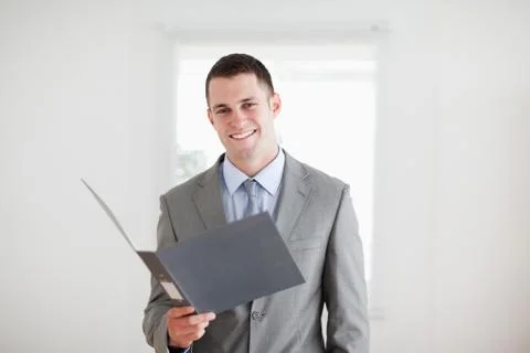 Smiling businessman with open folder Stock Photos
