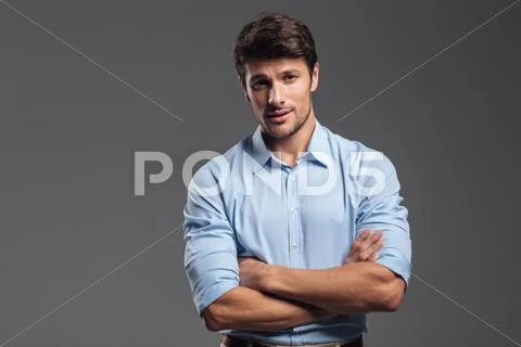 Smiling businessman standing with arms folded Stock Photos