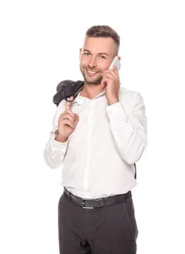 Smiling businessman talking on smartphone while holding jacket isolated on white Foto stock