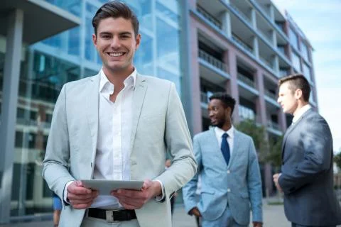 Smiling businessman using digital tablet in the office building Fotos de archivo